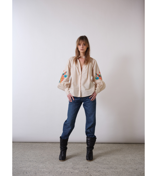 blouse beige avec des broderies sur les manches