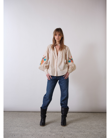 blouse beige avec des broderies sur les manches